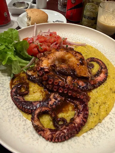Pulpo dorado sobre crema con papas confitadas