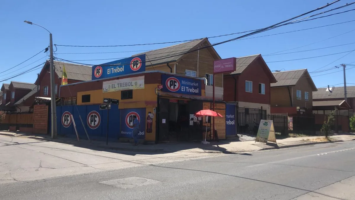 Fachada amarilla y azul del Minimarket El Trébol en la esquina
