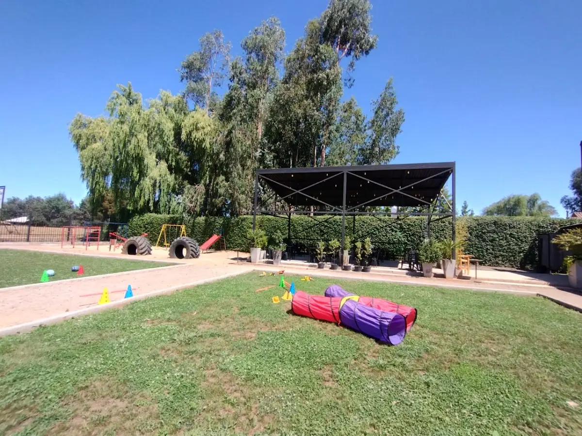 Jardín y terraza del restaurant: césped, sombrilla y puff para sentarse al aire libre
