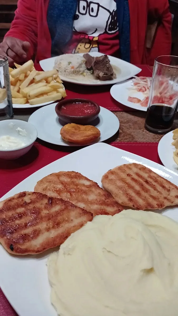 Parrilla encendida del restobar con carne y choripanes al fuego