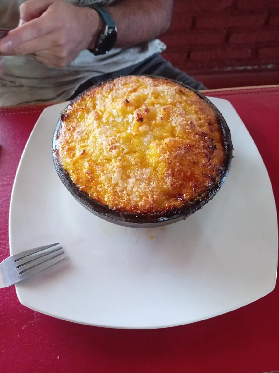 Pastel de choclo servido en plato de greda