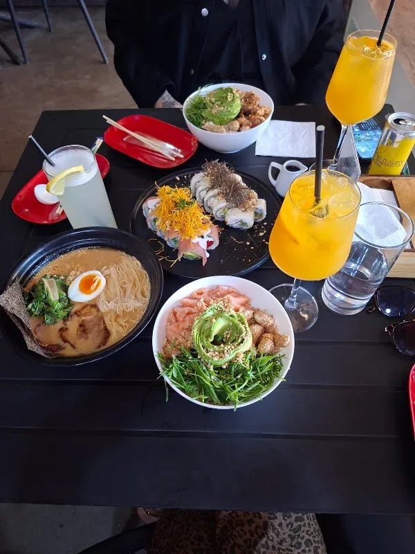 Mesa servida con varios platos y tragos en NARU