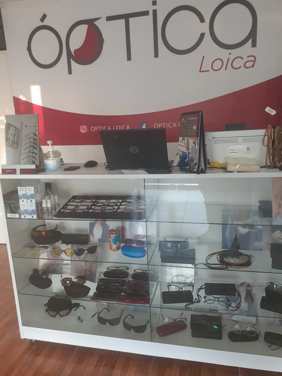 Letrero pintado ópTICA Loica sobre el mesón de la tienda, con vitrina de armazones