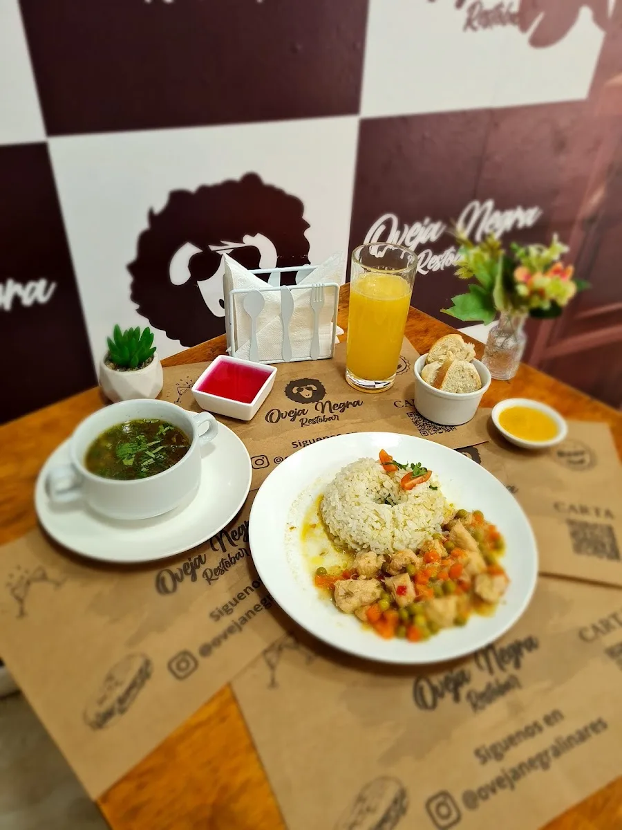 Mesa de Oveja Negra con su individual de marca, plato de fondo, consomé y jugo