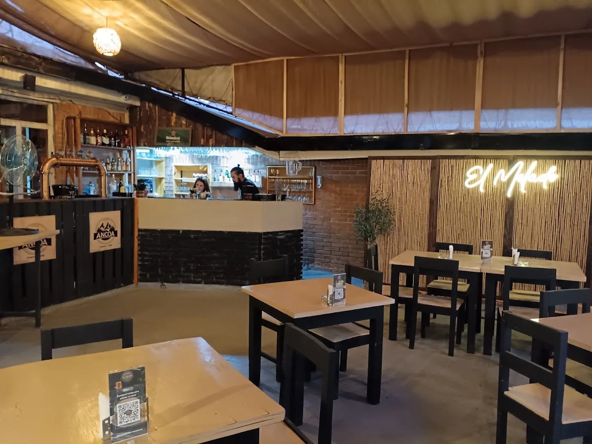 Interior del restobar con mesas y el letrero Oveja al fondo