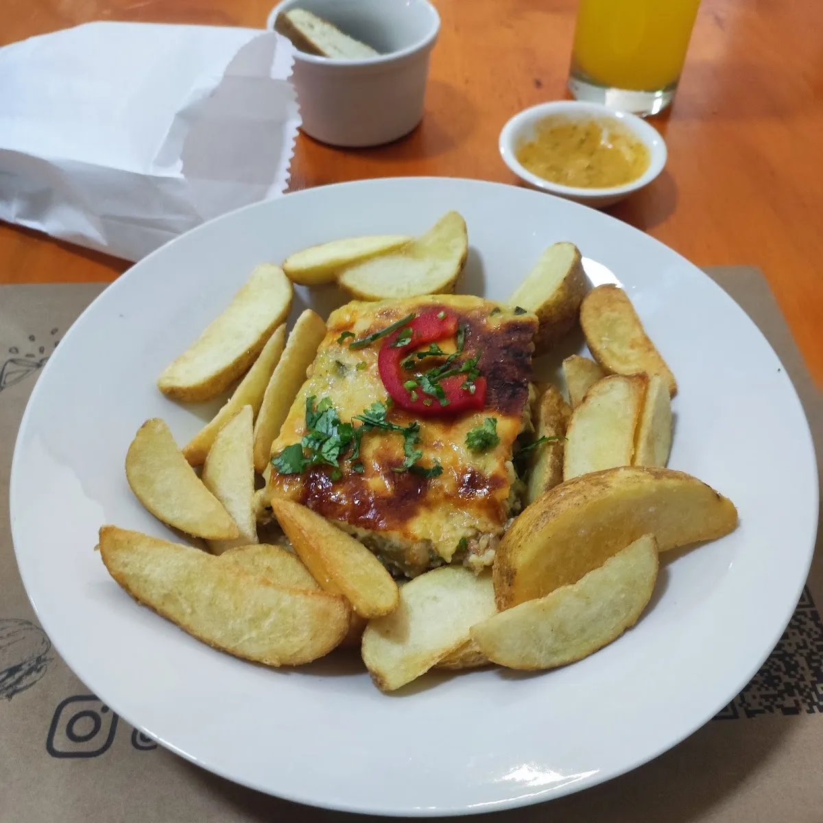 Salchipapas con pebre sobre mesa de madera