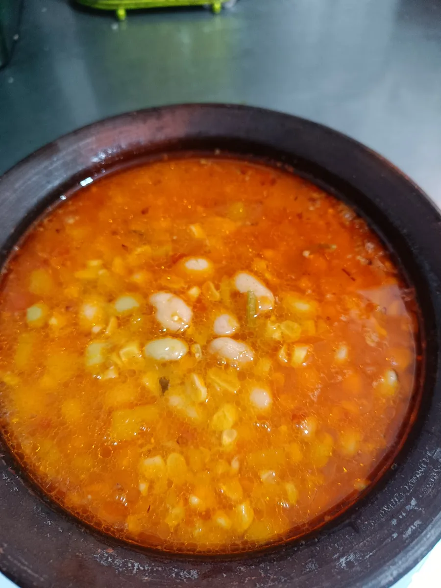 La paila de greda de la casa, caldo generoso servido al centro de la mesa