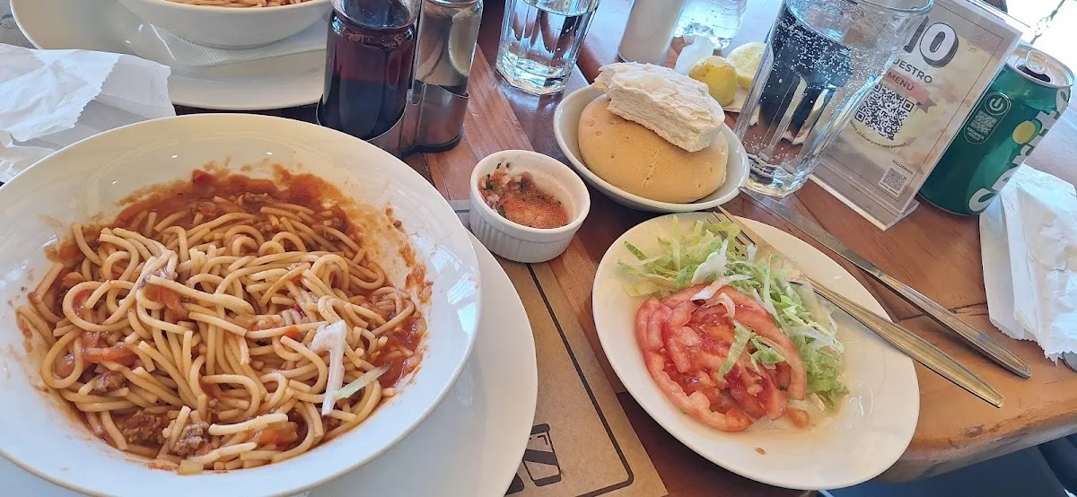 Mesa con almuerzo del día y marraqueta en Panadería La Moderna