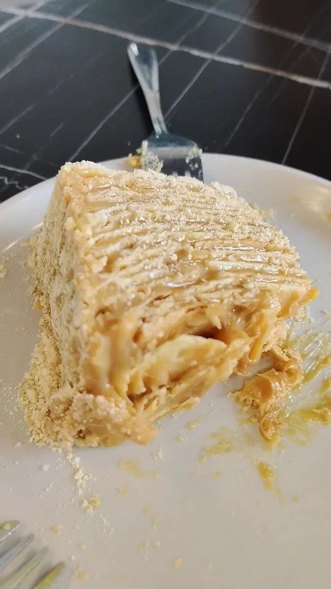 Trozo de mil hojas con manjar en plato blanco