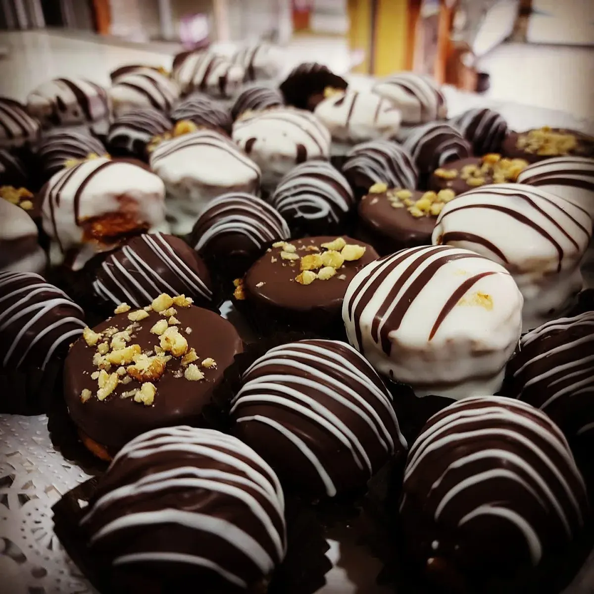 Dulces y alfajores cubiertos de chocolate en la vitrina de la pastelería