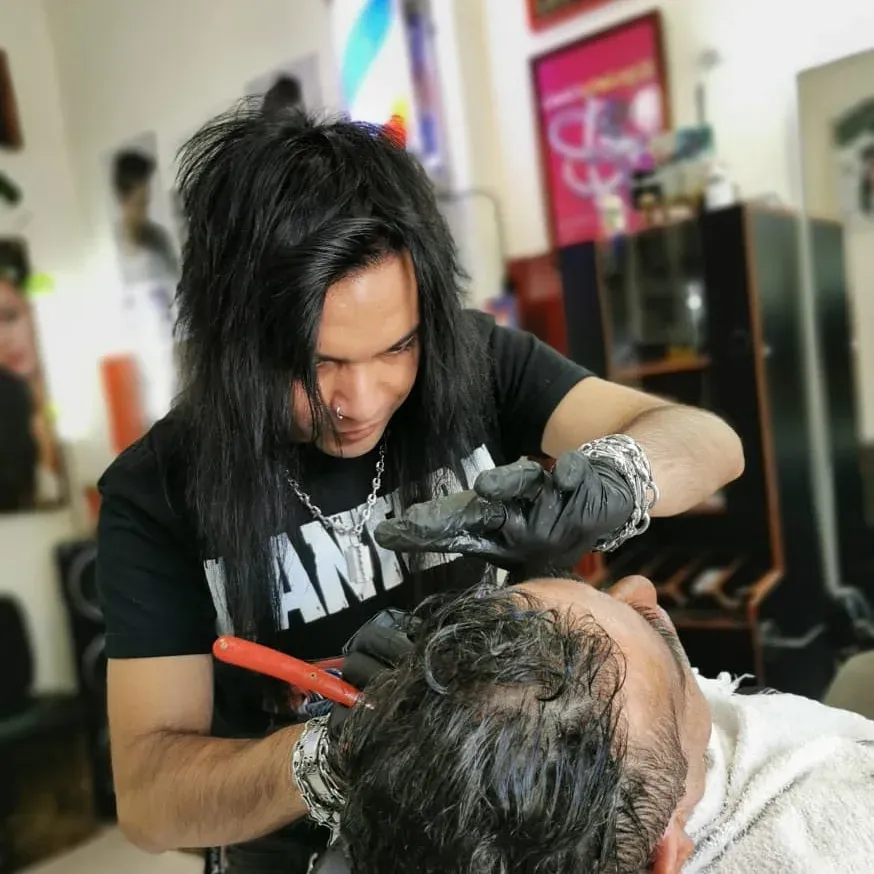 Diego cortando el pelo con tijera en la silla de Barber's Glam