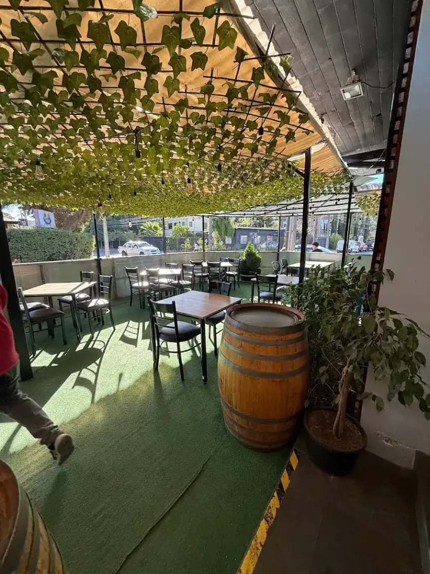 Terraza exterior con mesas de madera y toneles decorados