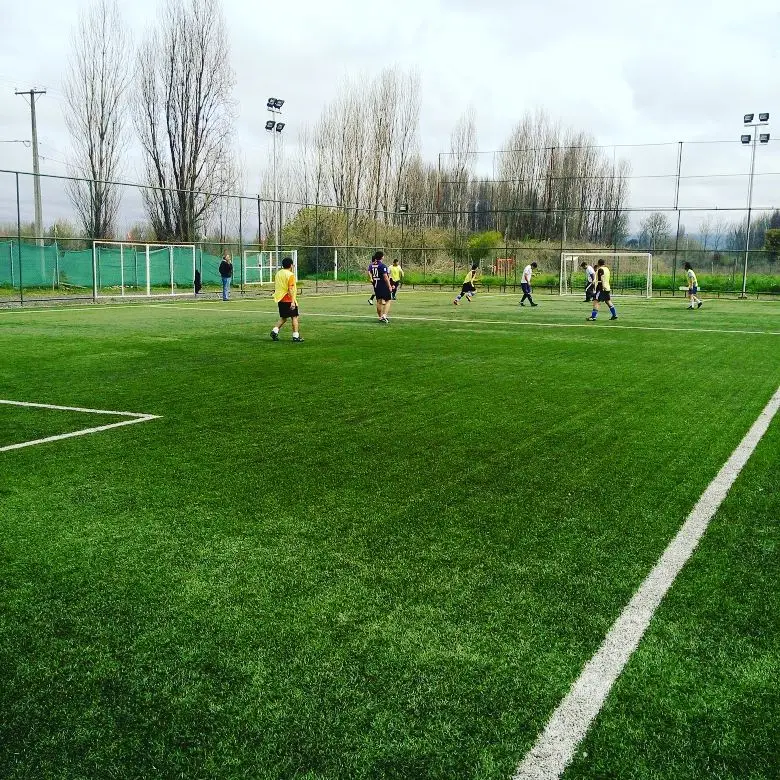 Partido de fútbol en la cancha de pasto sintético de Santa Adela