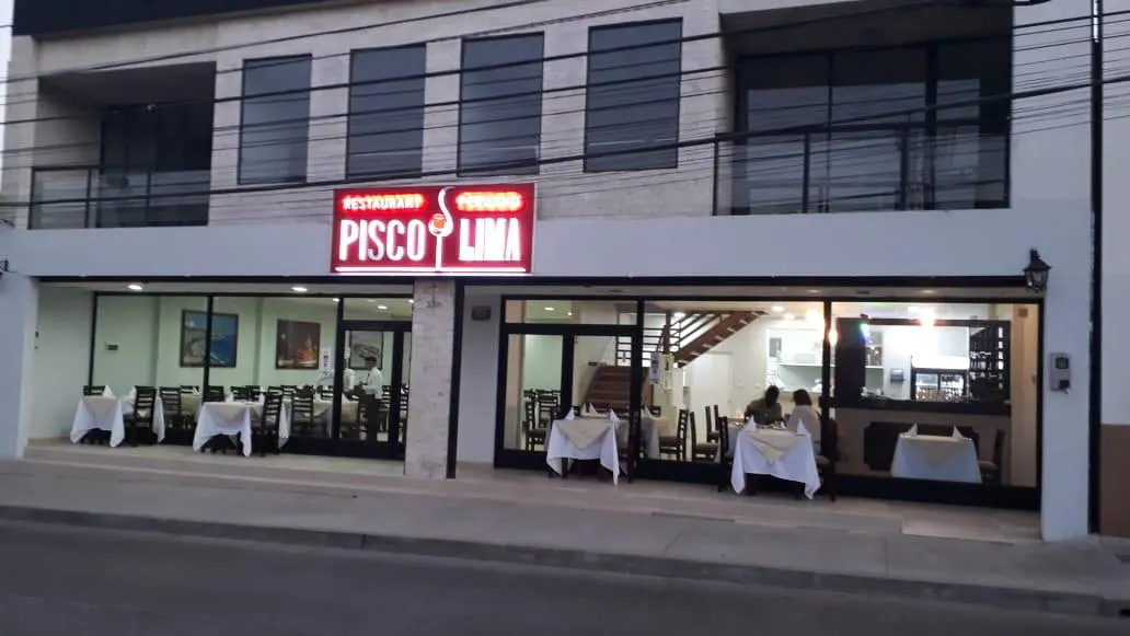 Fachada de Pisco & Lima en calle Cruz con su letrero magenta