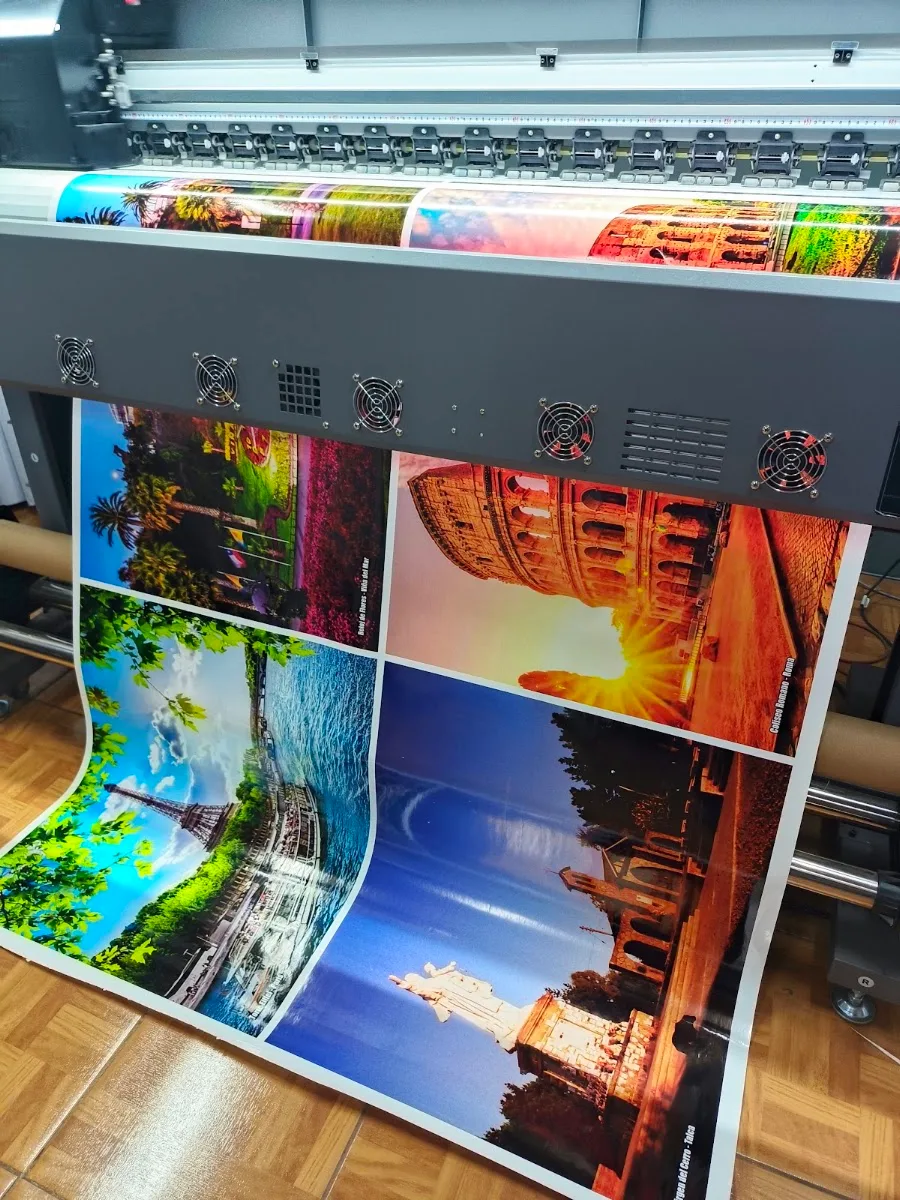 Impresiones fotográficas a todo color saliendo del plotter de gran formato