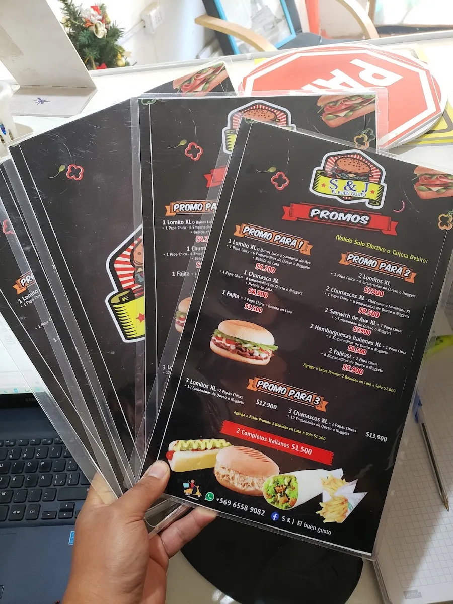 Cartas de menú laminadas del restaurant S&J El Buen Gusto apiladas sobre la mesa