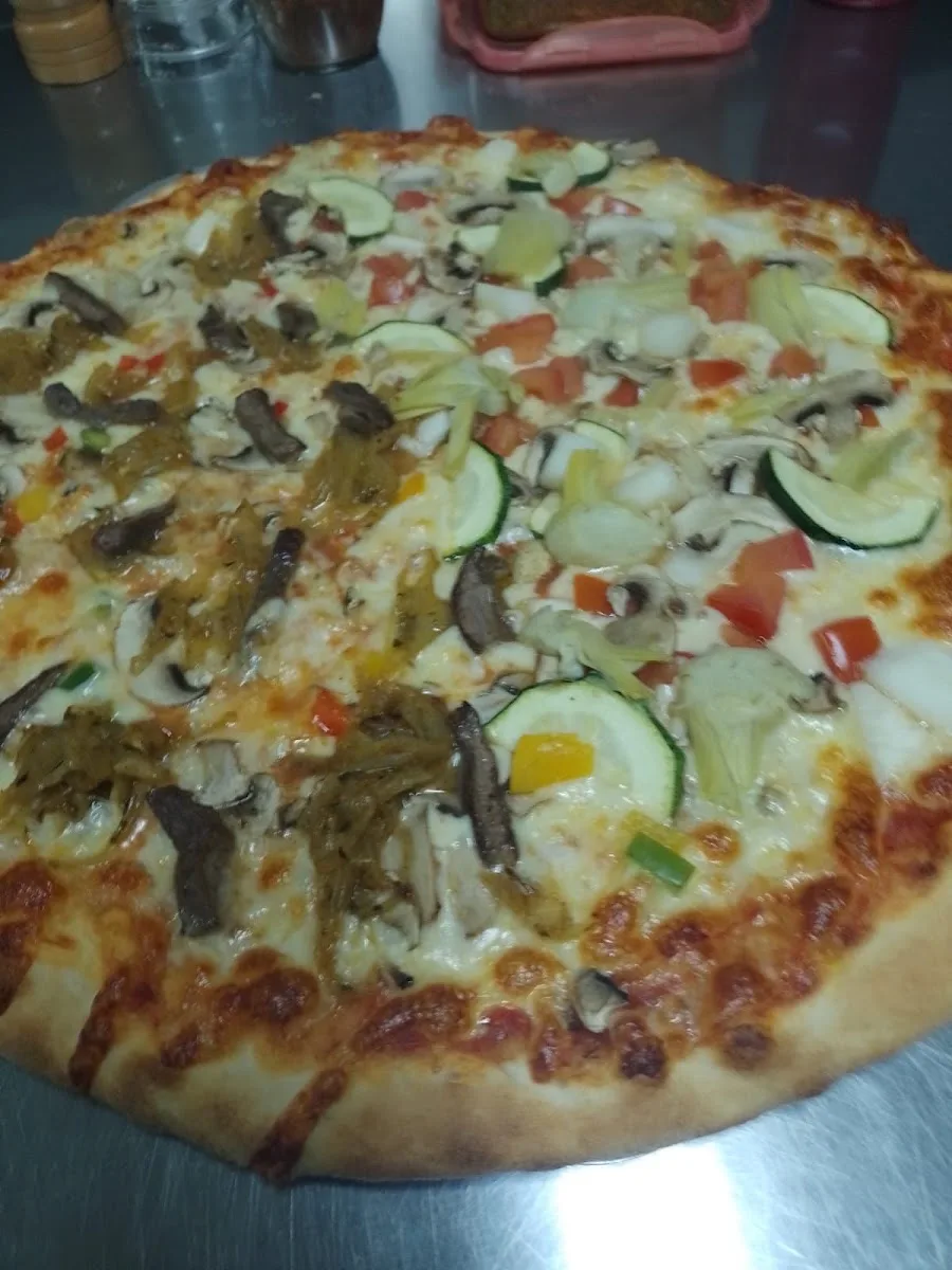 Pizza vegetariana de Pizzería la Toscana con zapallo italiano, cebolla y pimentón