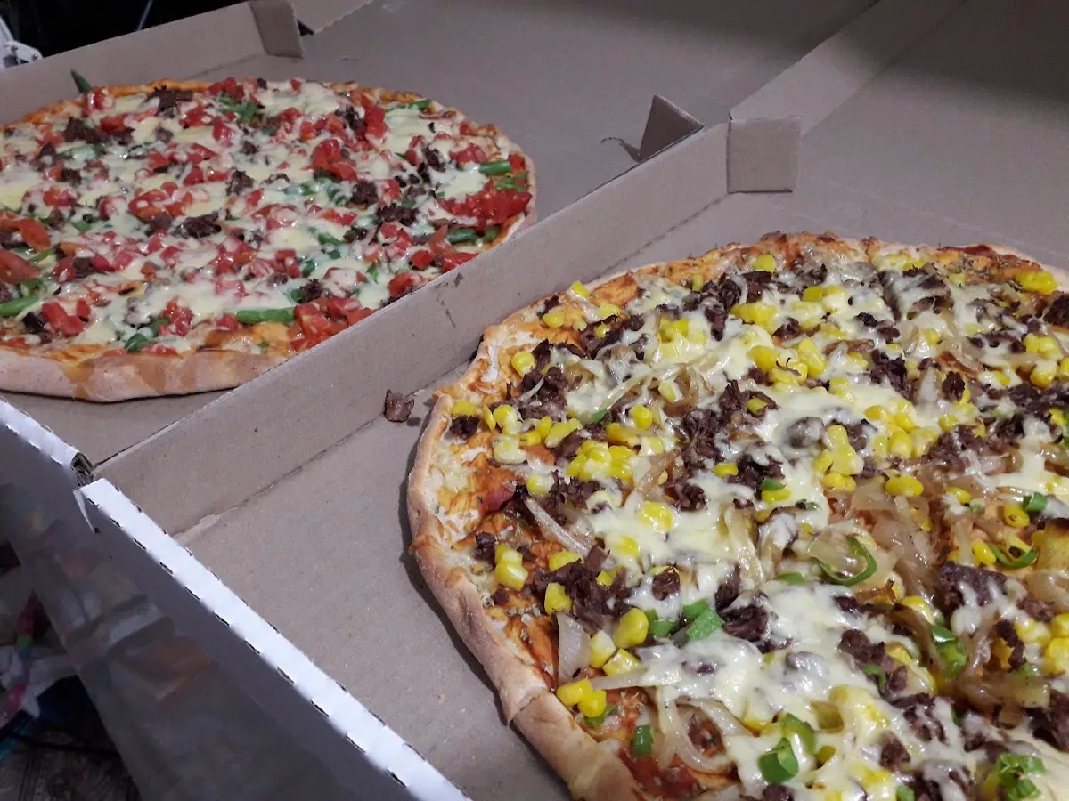 Dos pizzas familiares recién horneadas en sus cajas