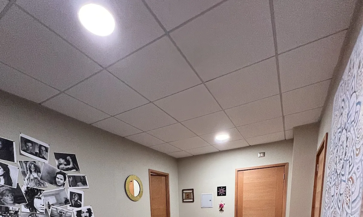 Muro de fotografías en blanco y negro y colgante de macramé en la consulta