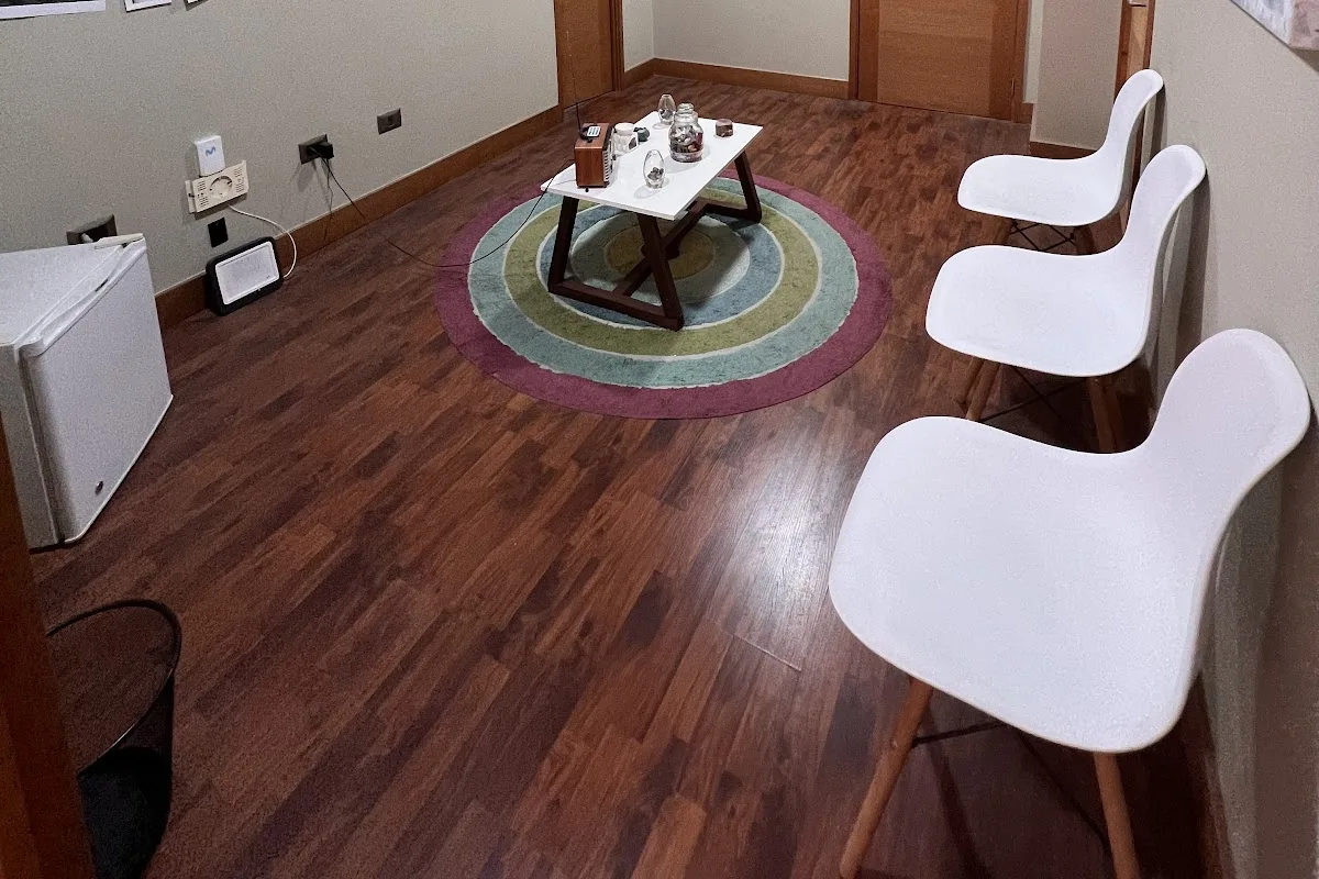 Sillas blancas sobre alfombra tejida de colores en la sala de consulta