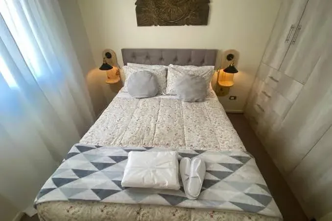 Dormitorio del hostal con cama de dos plazas y veladores