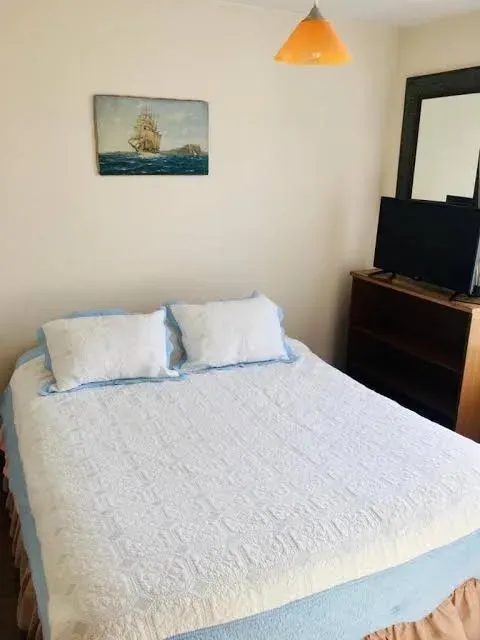 Dormitorio con cama azul y ventana al jardín