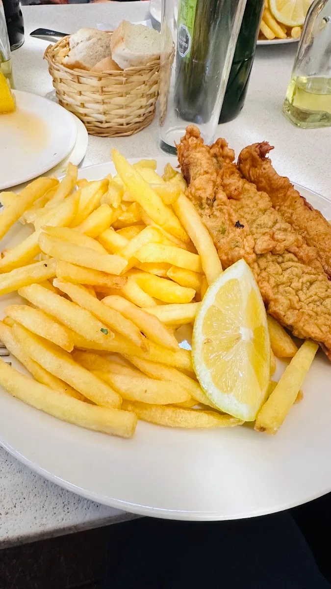 Pescado frito con papas fritas y limón