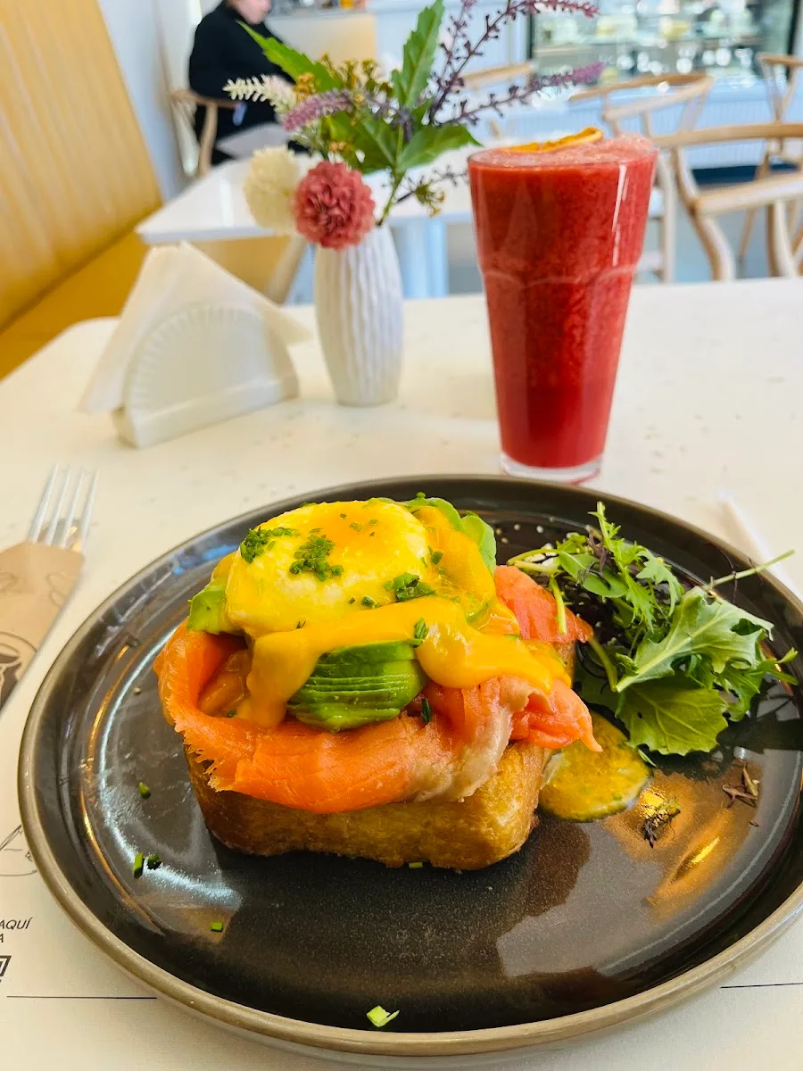 Tostada con salmón y huevo poché junto a un smoothie rojo, brunch de Ramona Café