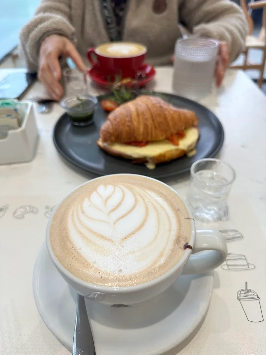 Croissant con café de especialidad sobre la mesa de Ramona Café