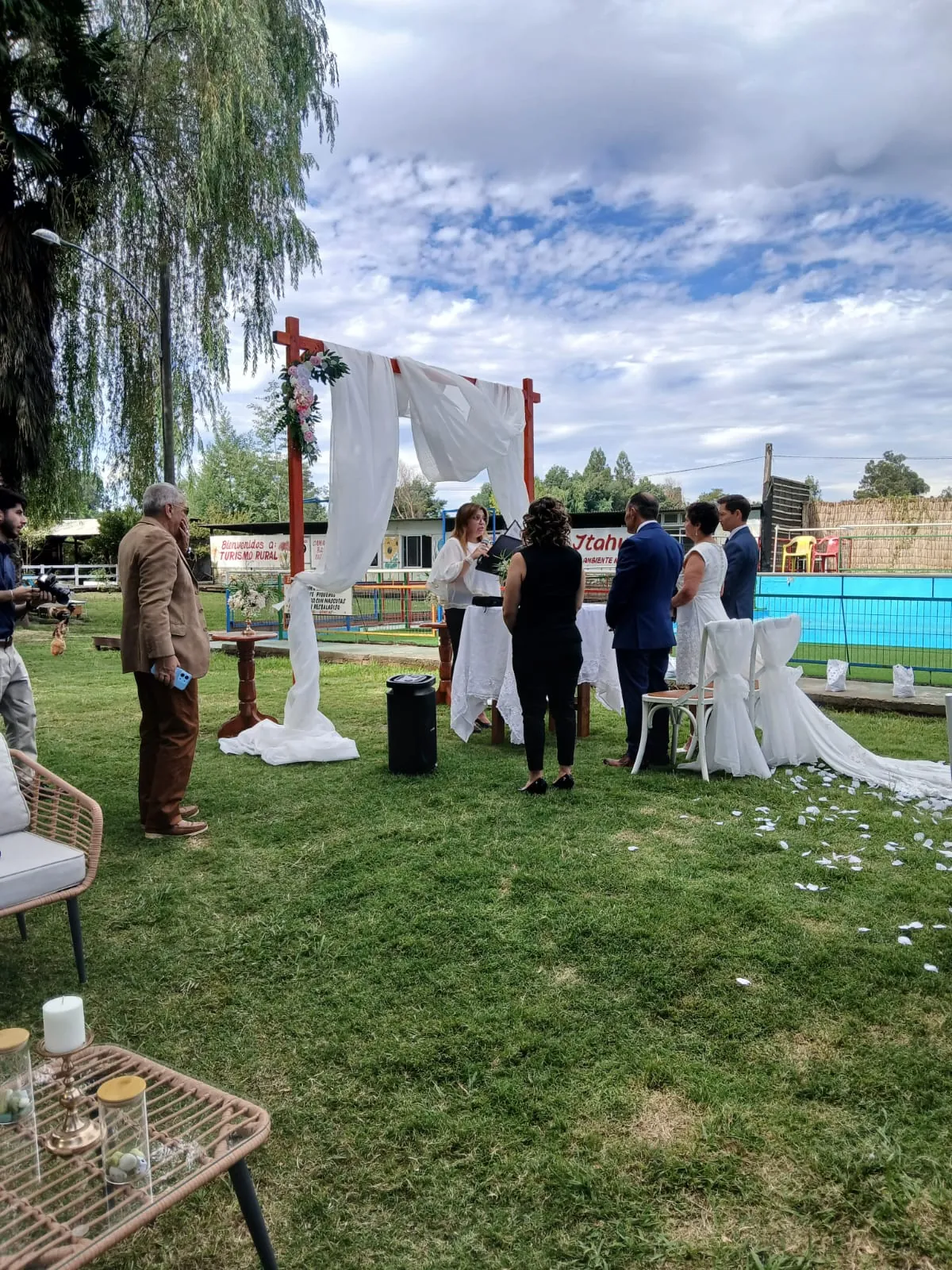 Ceremonia de matrimonio con arco blanco junto a la piscina