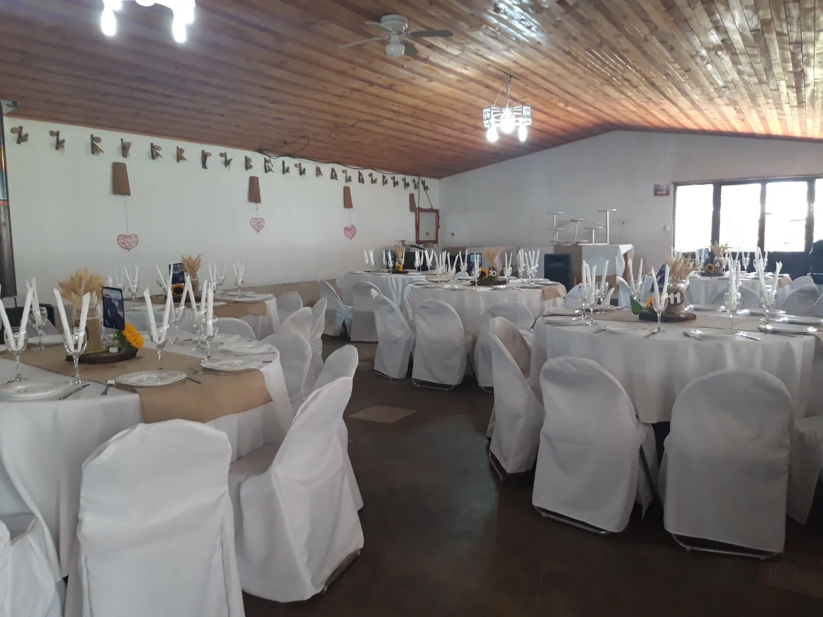 Salón preparado con mesas redondas de mantel blanco