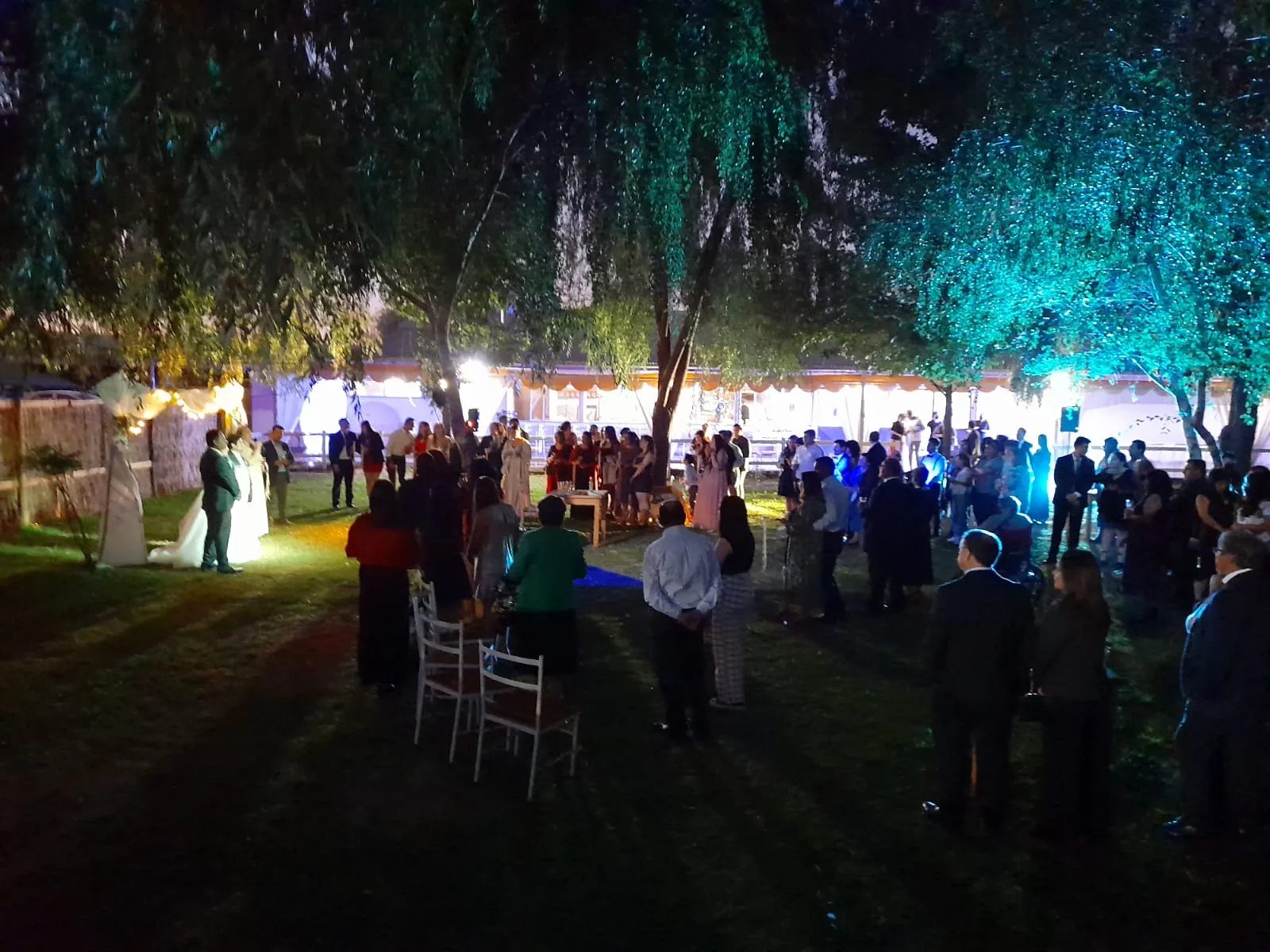 Invitados junto al salón iluminado en una celebración nocturna