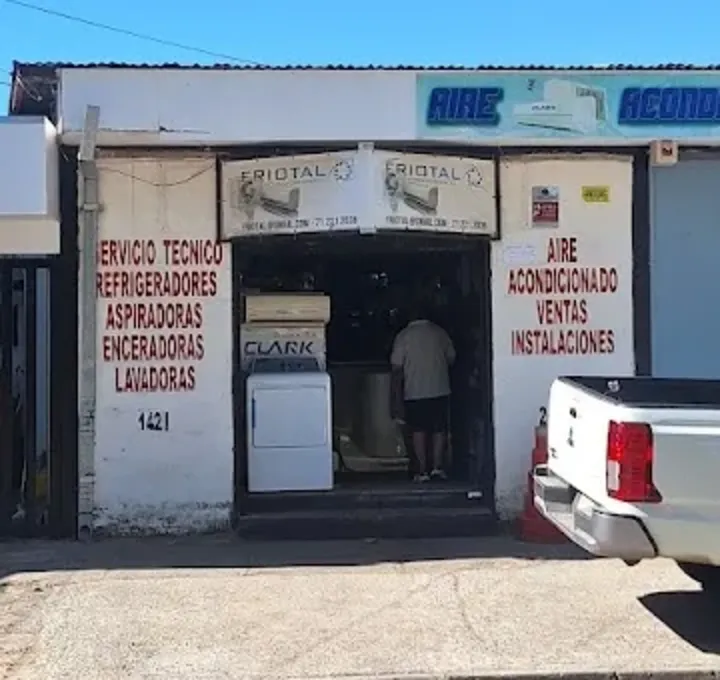 Detalle del muro del local de Friotal con el listado de servicio técnico pintado a mano