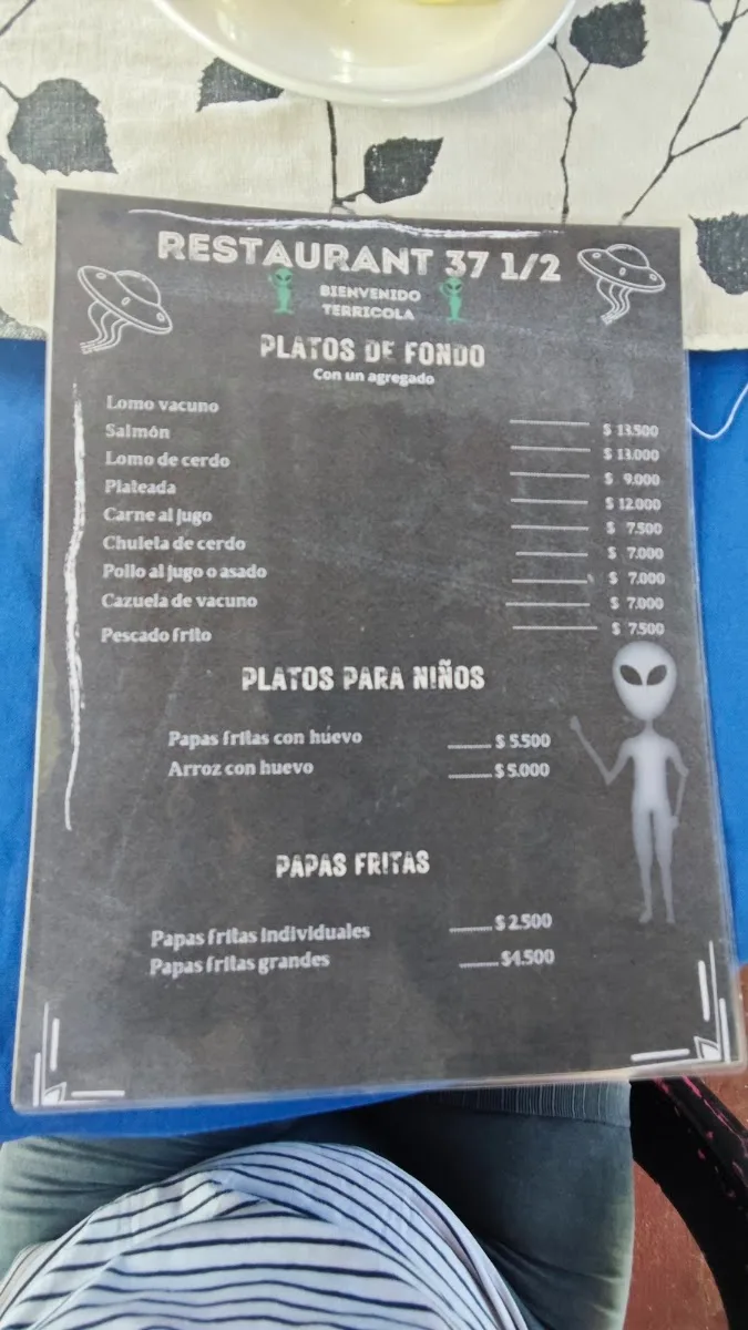 Carta del restaurante escrita en pizarra negra con el alienígena de la marca y precios
