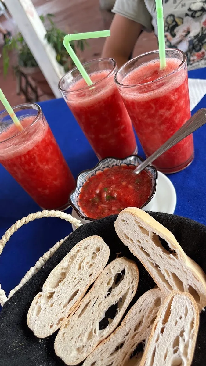 Mesa con jugos naturales de frutilla, pebre y pan amasado