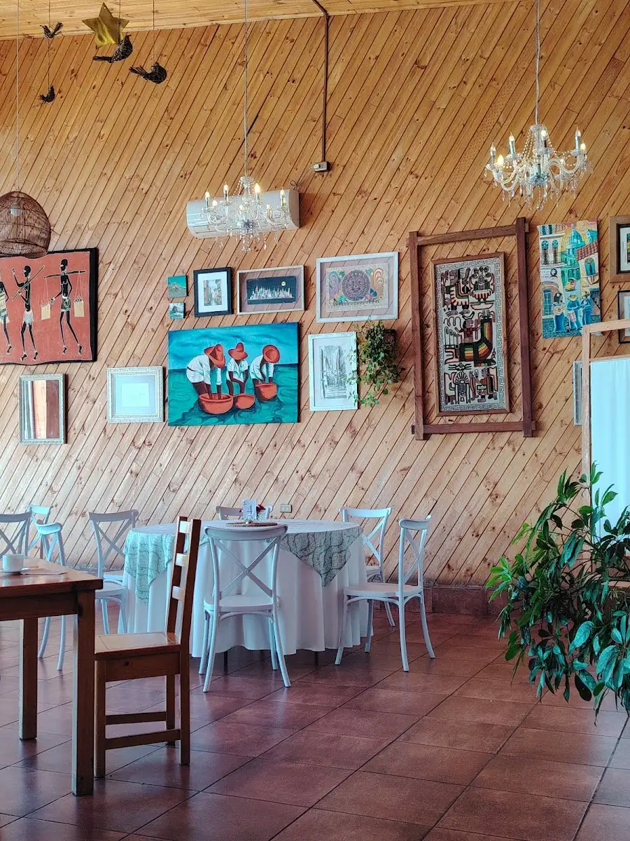 Salón principal de Casa del Mar: mesas con mantel blanco y decoración en el muro