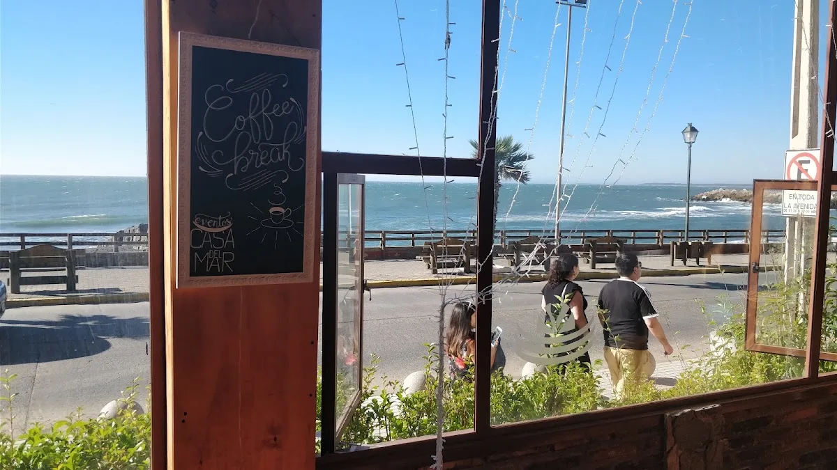 Vista al mar desde el interior: el marco de la puerta, la costanera y la playa