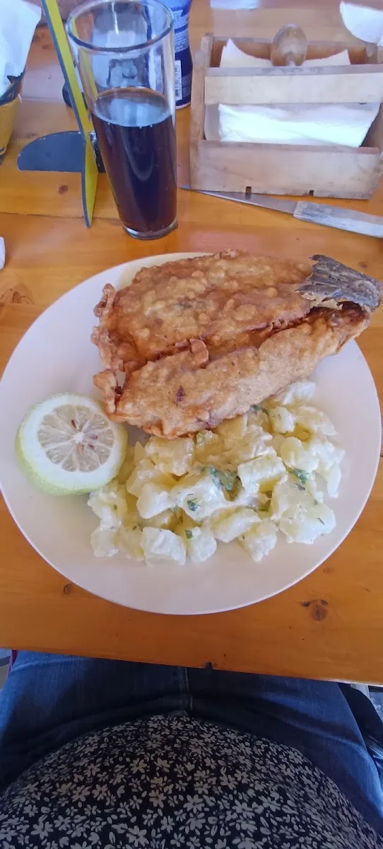 Pescado con ensalada y un vaso de vino en la terraza