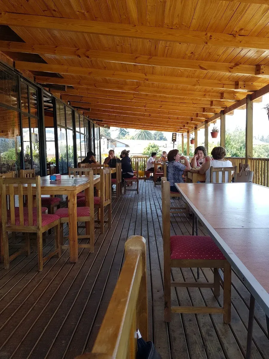 Terraza de madera de Donde Quelito con barra corrida, mesas y techo de madera