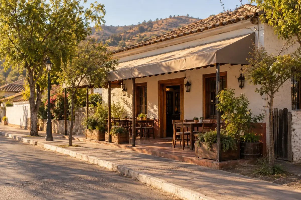 Fachada del restaurante en Pencahue: casa blanca con teja, toldo y mesas al aire libre