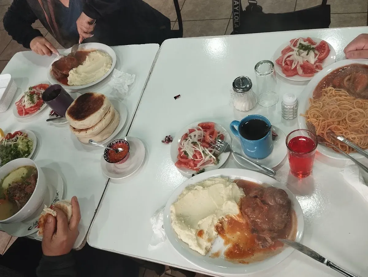 Familia sirviéndose cazuela, tortillas, pebre y ensaladas en la mesa de El Rancho