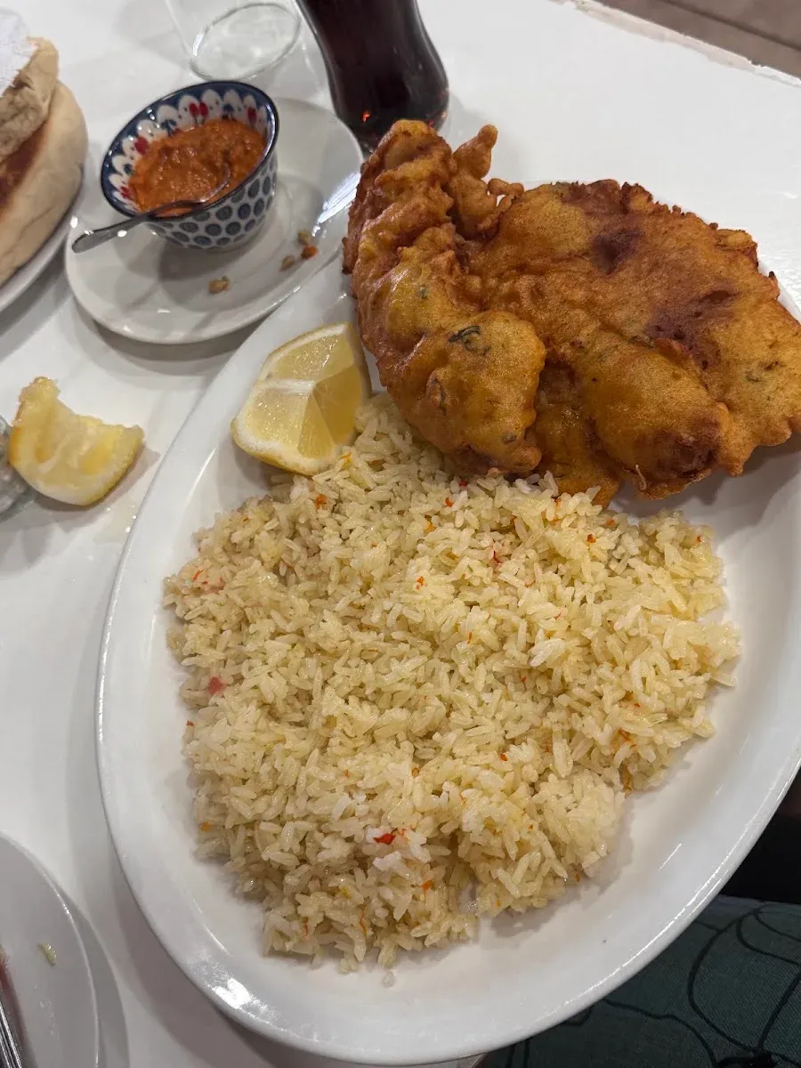 Pescado frito con arroz, limón y pebre