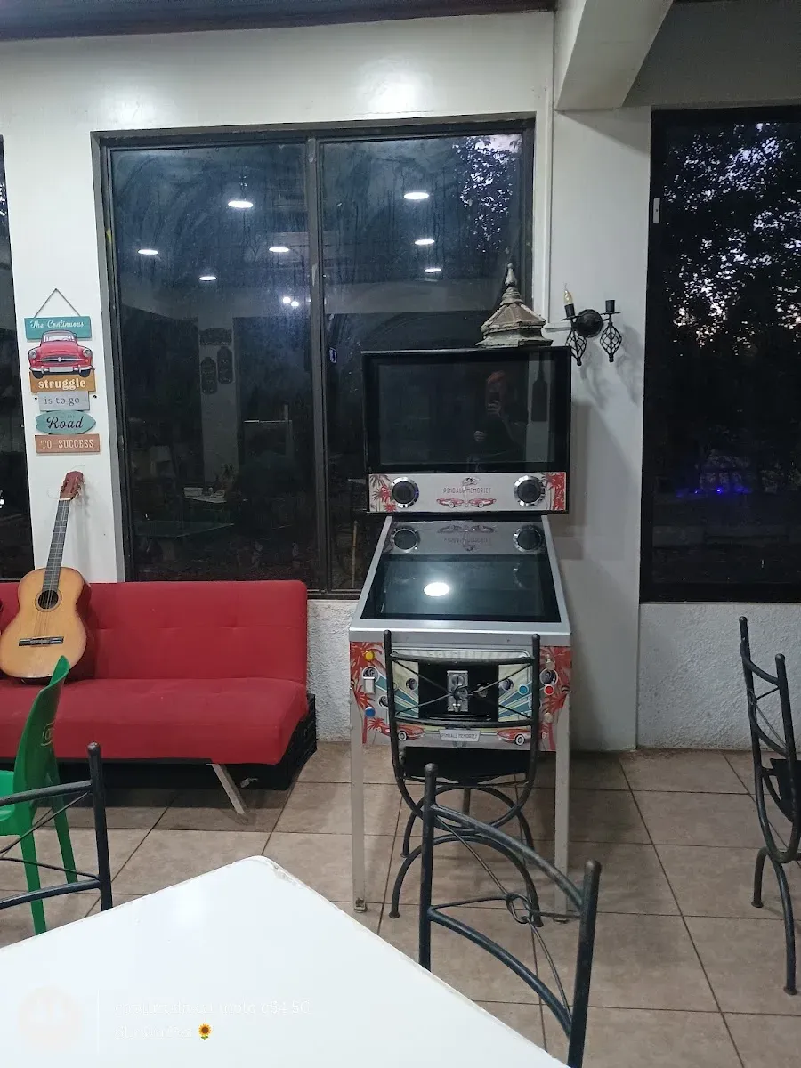 Pinball, guitarra y sillón rojo en el salón de El Rancho
