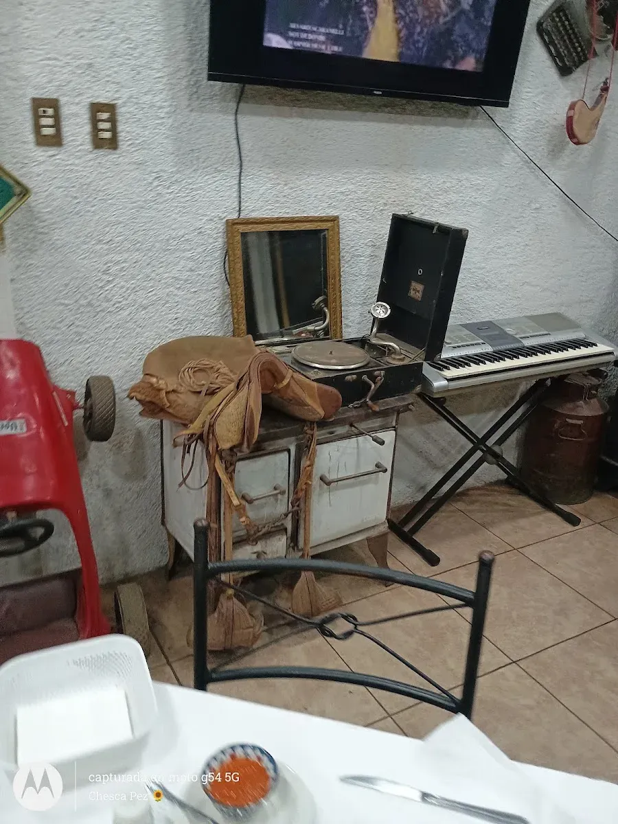 Rincón de antigüedades de El Rancho: televisor antiguo, sillín, teclado y máquina de coser