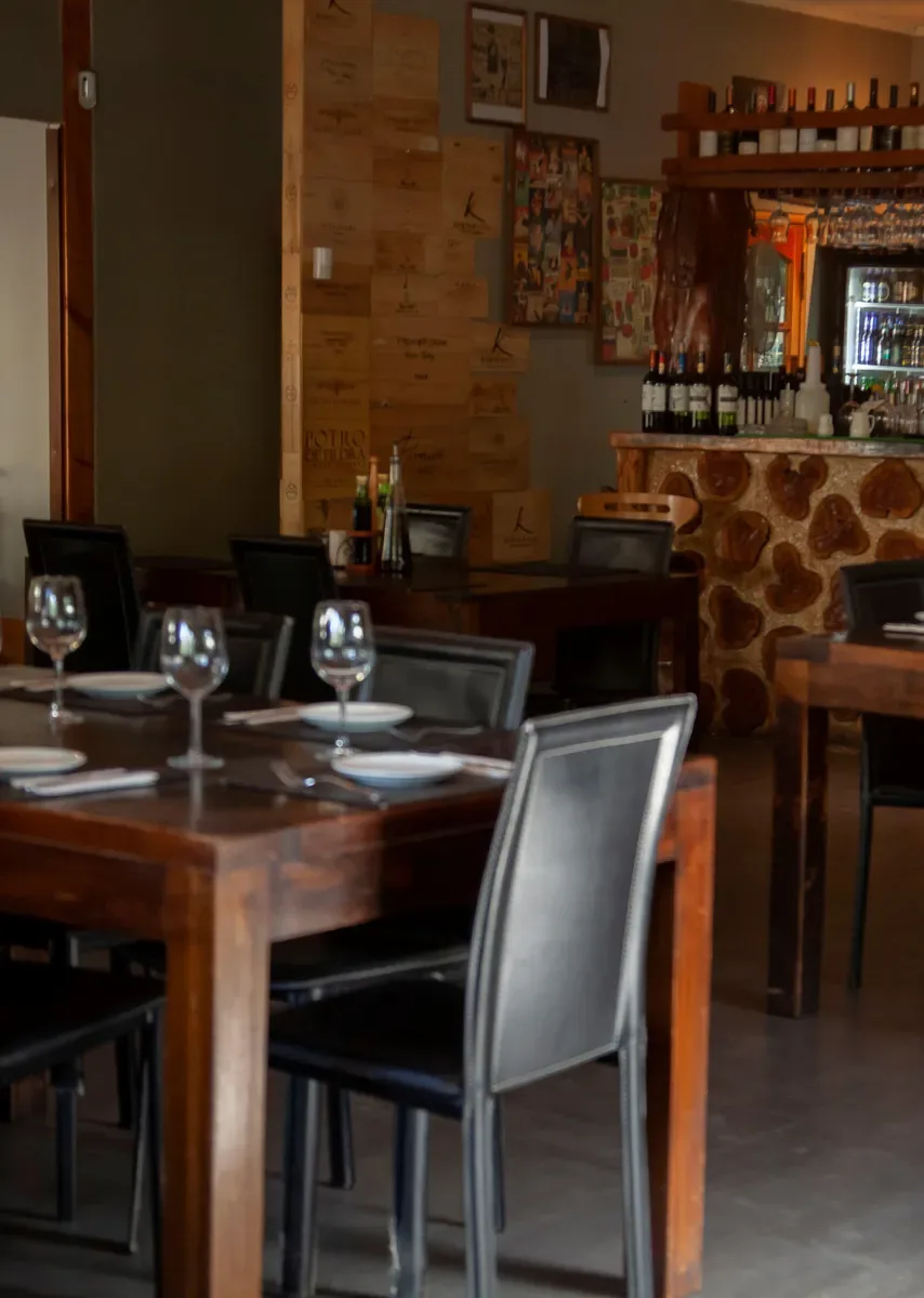 Comedor interior de madera con mesas servidas en Fuego Bendito