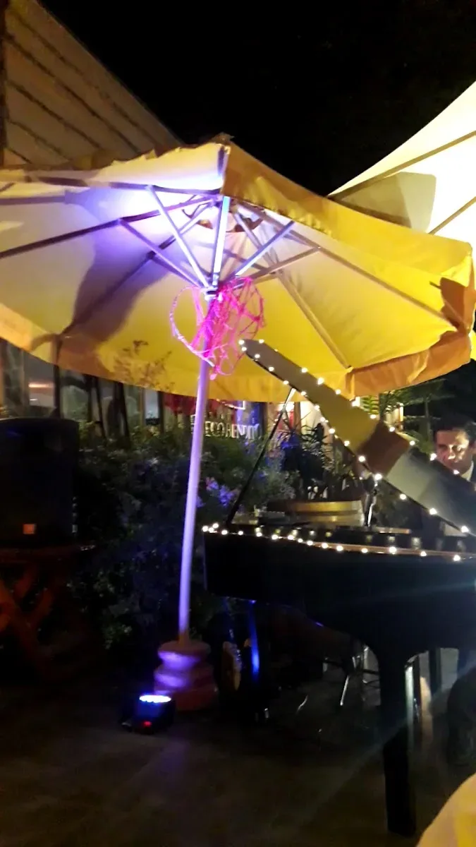 Terraza de noche con sombrillas iluminadas en Fuego Bendito