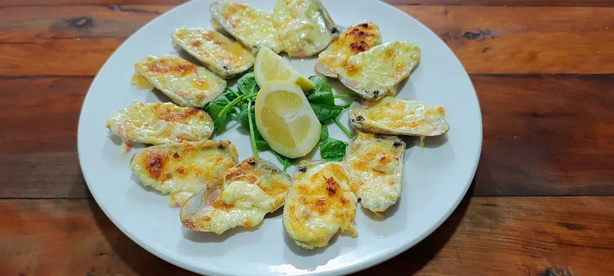 Machas a la parmesana con limón y rúcula