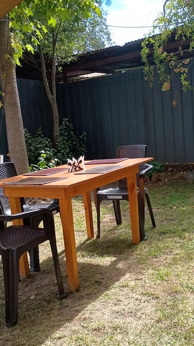 Mesa de madera en el patio de Mane bajo los árboles