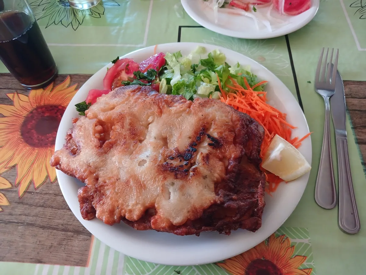 Pescado frito con ensalada surtida servido en el restaurante