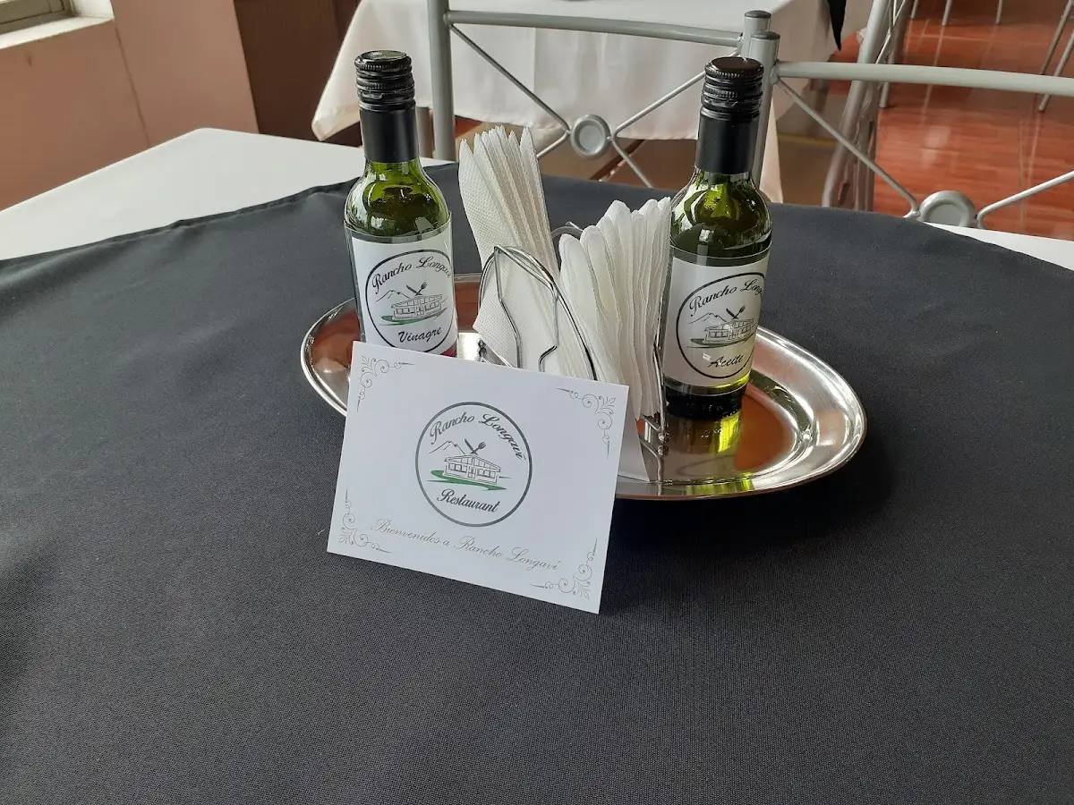 Mesa con vinagretas y tarjeta de bienvenida con el logo de Rancho Longaví